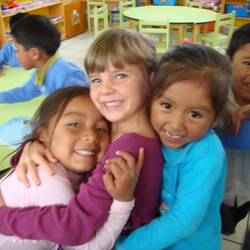 Happy children in school in Peru, one is from the U.S.